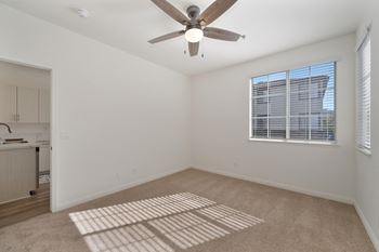Room with a ceiling fan and a window with blinds.